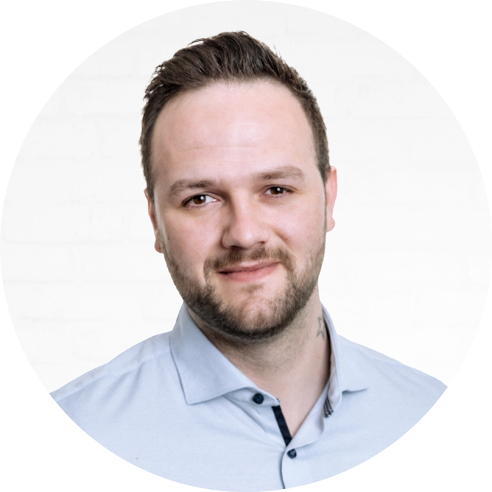 Porträt des IT-Consultants Manfred Schuster vor einer neutralen Wand aus weißen Backsteinen.