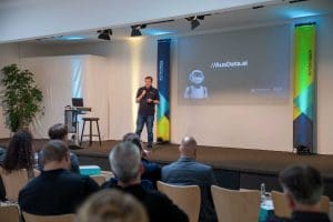 Vortrag beim Kutzschbach Partnertag 2025 mit Präsentation zu AuxData.ai und Publikum im Konferenzraum